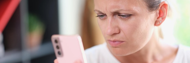 Mujer infeliz leyendo mensajes en su teléfono inteligente concepto de malas noticias mujer con cara seria