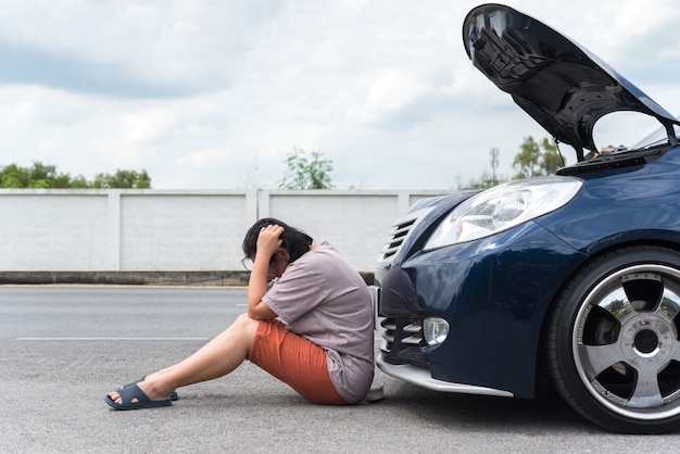 Mujer infeliz y triste por el problema del motor del automóvil