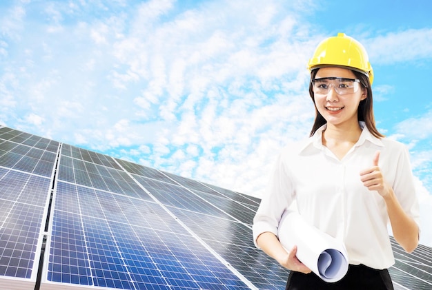 Mujer ingeniera asiática en un casco trabaja en la base solar de energía