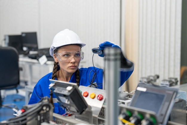 Mujer ingeniera revisando e inspeccionando la máquina de control en la línea de producción en la fábrica