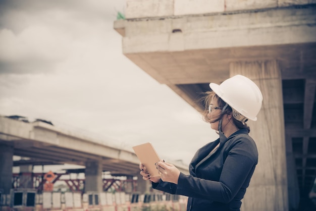Mujer ingeniera trabajando en el sitio del puente en construcción