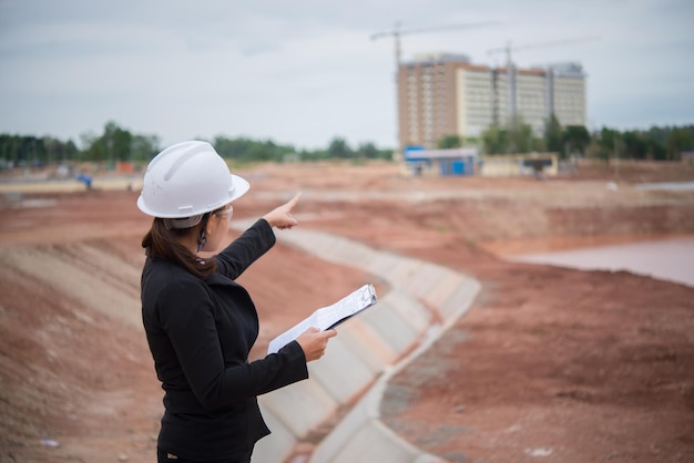 Mujer ingeniera trabajando en el sitio del puente en construcción