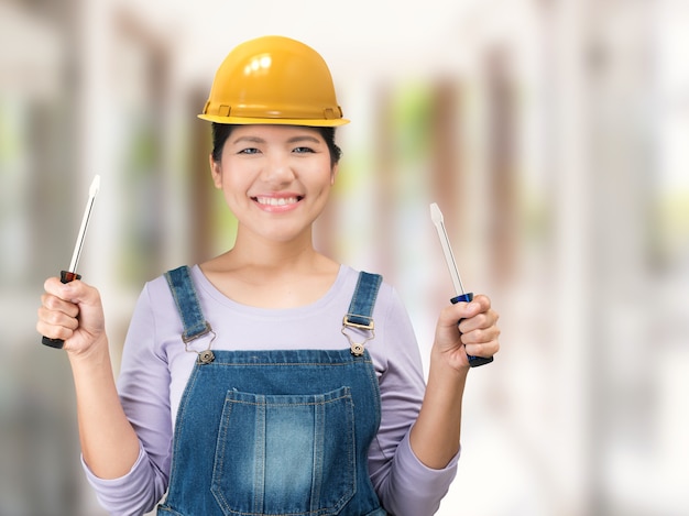 Mujer de ingeniería asiática vistiendo mono y casco de seguridad