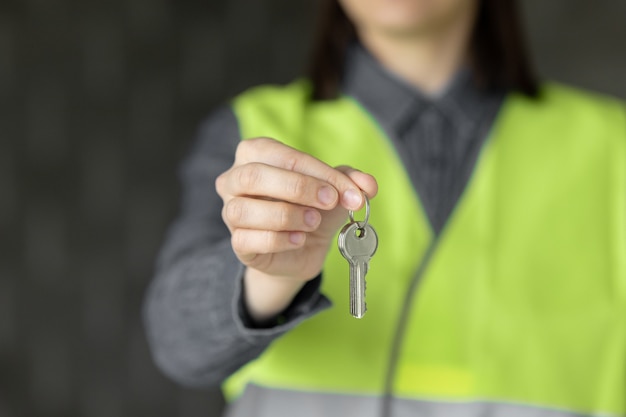 Mujer ingeniero en un casco blanco y chaleco de seguridad el ingeniero en el sitio de construcción