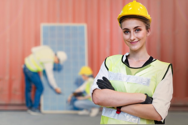 Mujer ingeniero de pie con confianza frente al panel de células solares para energía renovable