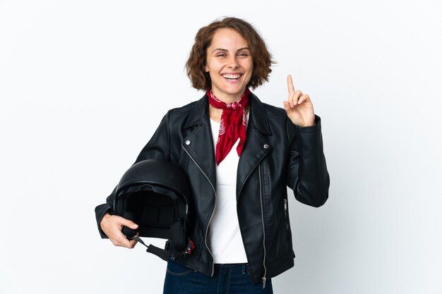 Mujer inglesa sosteniendo un casco de motocicleta aislado en una pared blanca apuntando hacia una gran idea