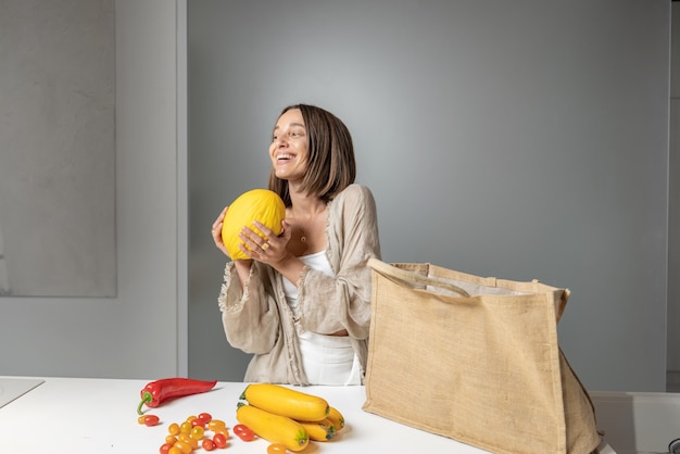 Foto mujer con ingredientes de alimentos crudos en la cocina moderna en casa