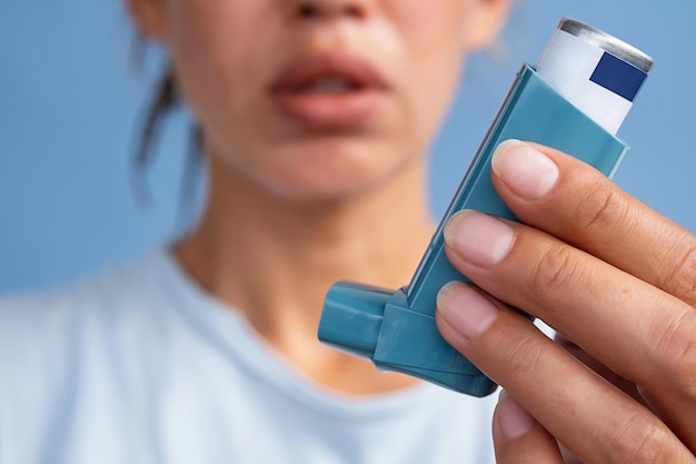 Mujer con un inhalador de medicamentos para el asma
