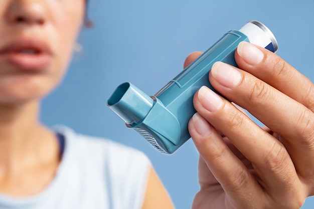 Mujer con un inhalador de medicamentos para el asma