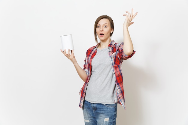 Mujer insatisfecha irritada en ropa casual sosteniendo lata de pintura vacía con espacio de copia y agitando la mano aislada sobre fondo blanco. Instrumentos para la renovación de la habitación del apartamento. Reparar el concepto de hogar.