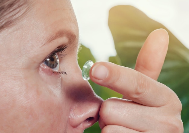 Mujer inserta una lente de contacto en el ojo