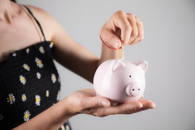 Mujer insertando una moneda en una alcancía