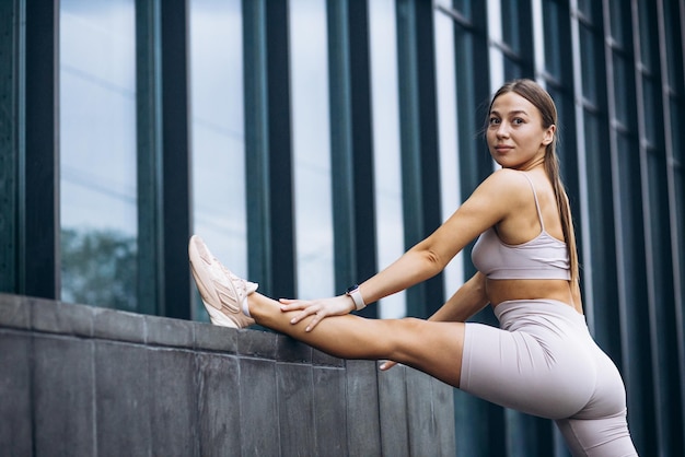 Mujer instructora de fitness que se extiende por el edificio