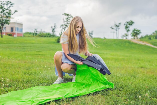 Una mujer intenta inflar un sofá de aire.