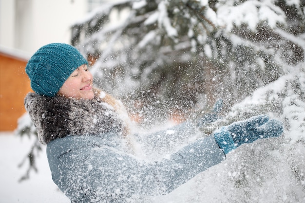 Mujer durante el invierno jugando con nieve