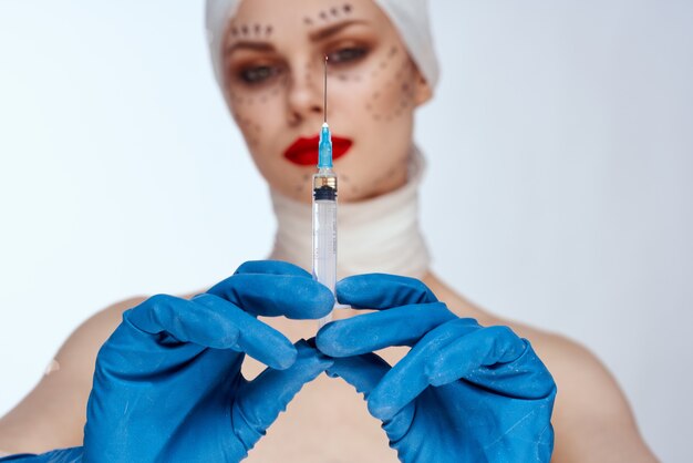 Mujer con inyecciones de jeringa de belleza retrato de belleza en el estudio sobre un fondo blanco.