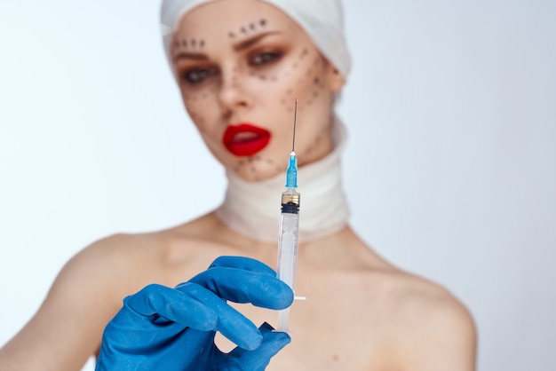 Foto mujer con inyecciones de jeringa de belleza retrato de belleza en el estudio sobre un fondo blanco.