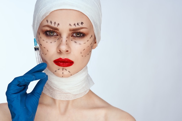 Mujer con inyecciones de jeringa de belleza retrato de belleza en el estudio sobre un fondo blanco.