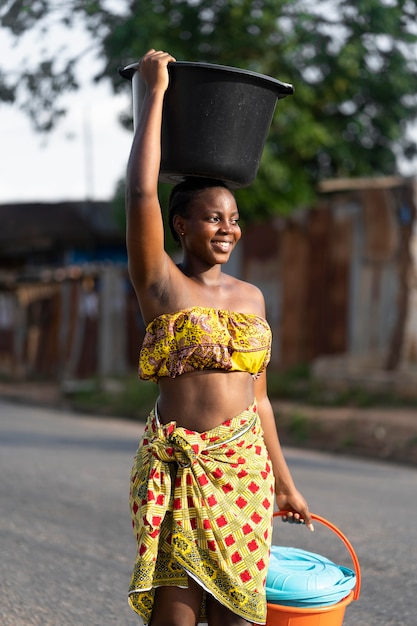 Foto mujer, ir a buscar agua, aire libre