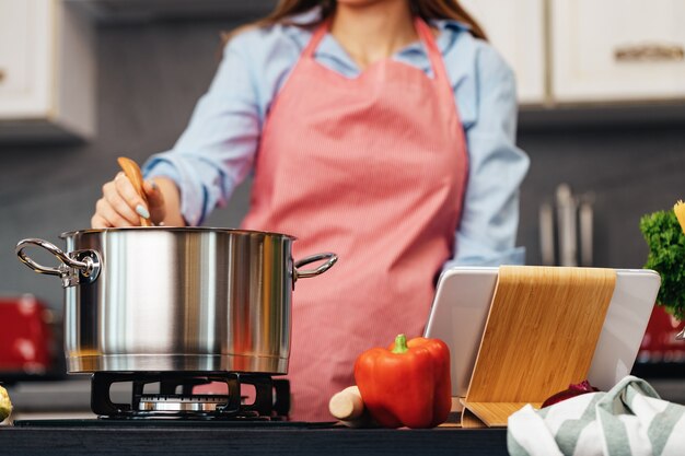 Foto mujer irreconocible cocinando en su cocina de cerca