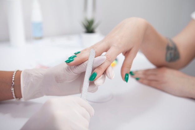 Mujer irreconocible con sus uñas archivadas por manicurista profesional