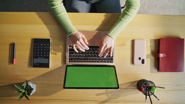 Mujer irreconocible trabajando con una computadora portátil en casa de cerca con las manos de una mujer escribiendo en la computadora
