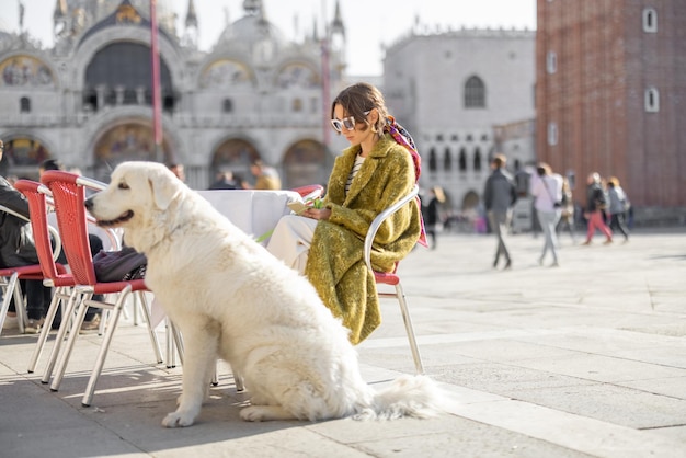 Mujer italiana con perro en un café en el centro de Venecia