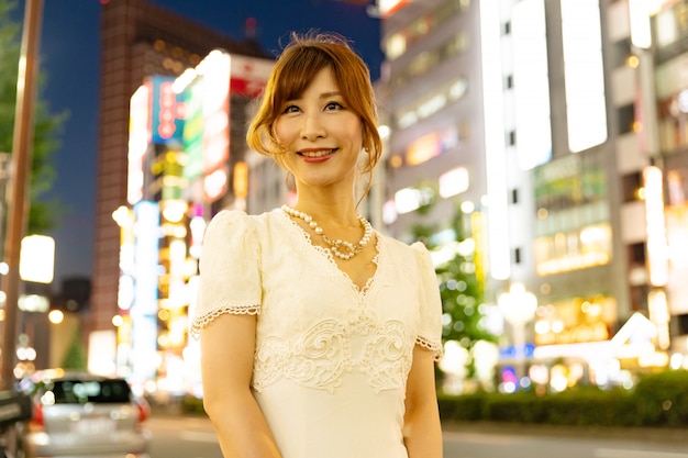 Mujer japonesa con glamoroso vestido blanco en las calles de Tokio, Japón