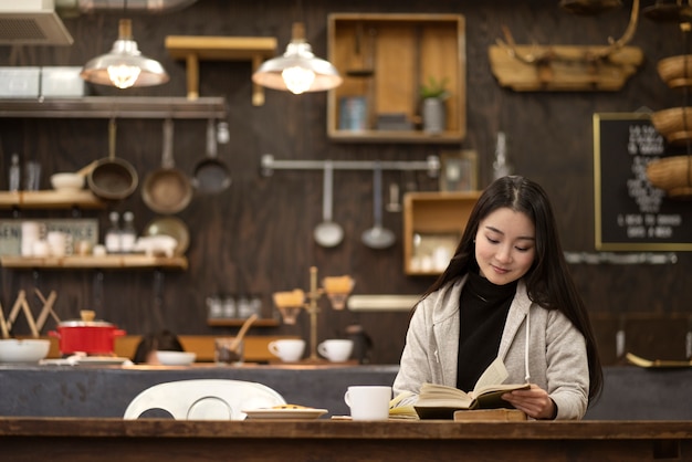 Mujer japonesa leyendo un cuaderno en un restaurante