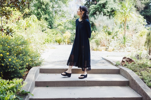 Mujer japonesa de mediana edad con vestido informal negro en el parque de verano