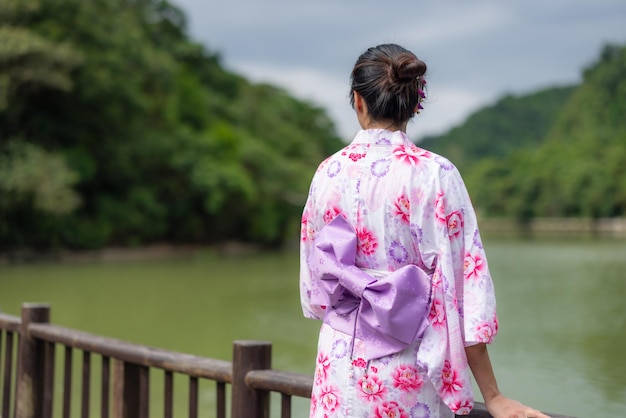 Una mujer japonesa usa un yukata en un parque al aire libre