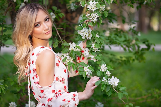 Una mujer en un jardín florido con un vestido blanco claro