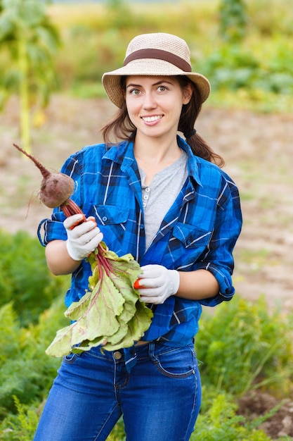 Mujer jardinera con remolacha orgánica en el huerto