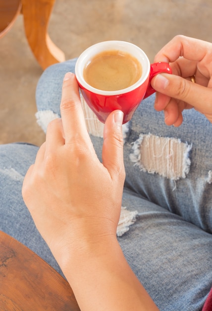 Mujer en jeans rotos sentado en la cafetería