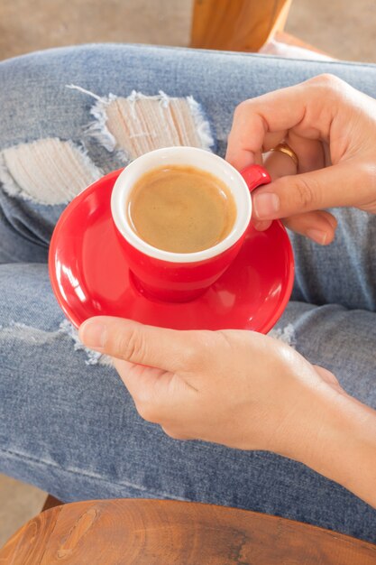 Mujer en jeans rotos sentado en la cafetería