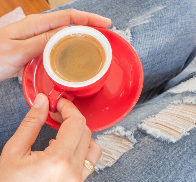 Mujer en jeans rotos sentado en la cafetería