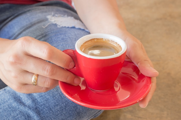 Mujer en jeans rotos sentado en la cafetería