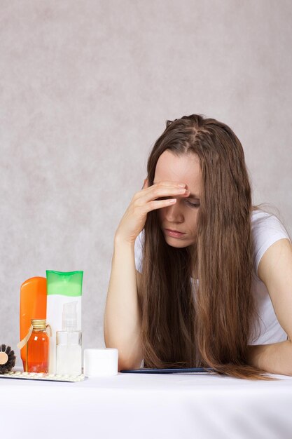 Mujer joven entre 30 y 40 años con cabello largo y liso cerca del kit de cuidado del cabello