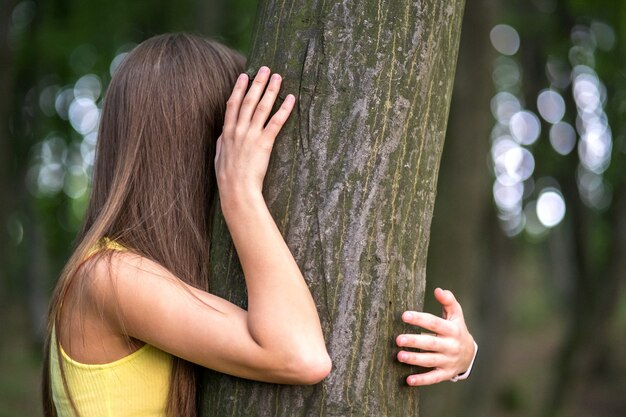 Mujer joven, abrazar, un, árbol