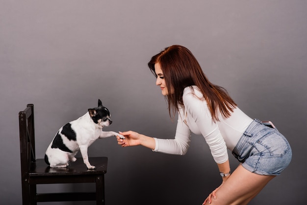 Mujer joven, abrazar, chihuahua, perrito, en, estudio, aislado