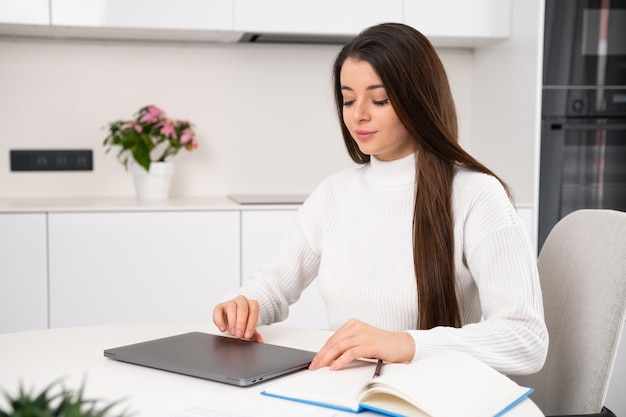 Mujer joven abre portátil para seguir haciendo la tarea