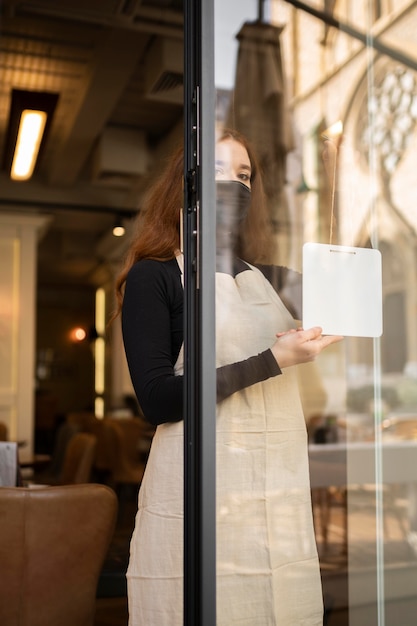 Foto mujer joven abriendo restaurante