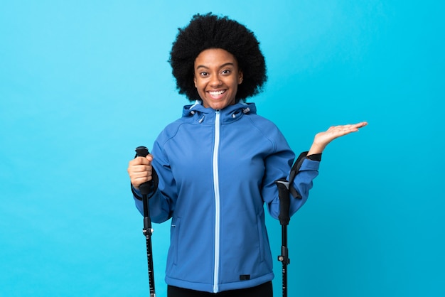 Mujer joven con un abrigo con bastones de trekking