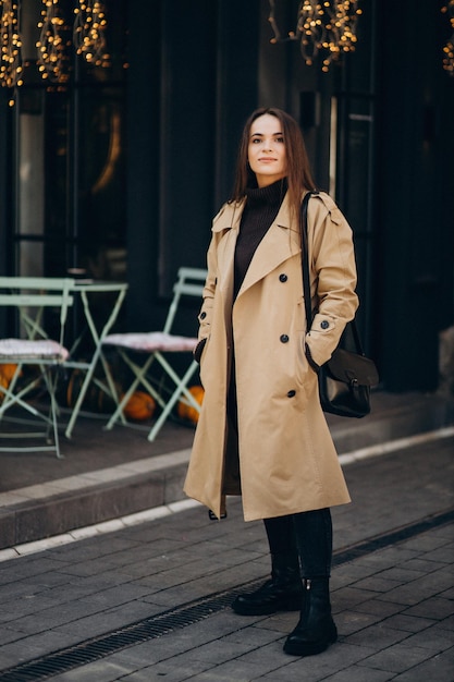 Mujer joven en abrigo caminando por el café