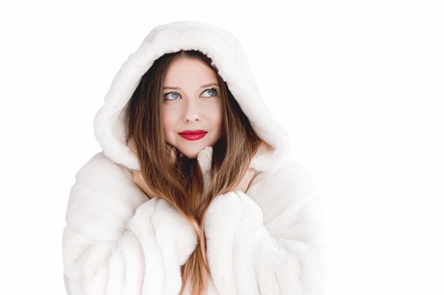 Mujer joven en abrigo de piel esponjoso con capucha envuelve ropa de invierno cálida para la moda y las vacaciones de Navidad