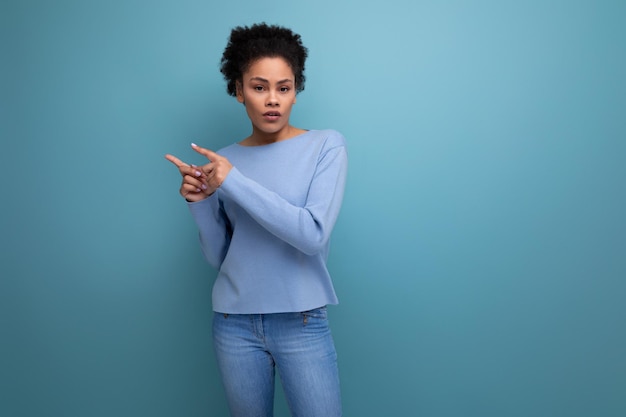 Mujer joven aburrida con apariencia de modelo de cabello afro pensando en el estudio