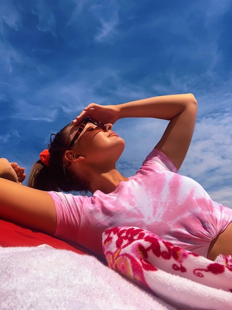 Foto mujer joven acostada al aire libre contra el cielo