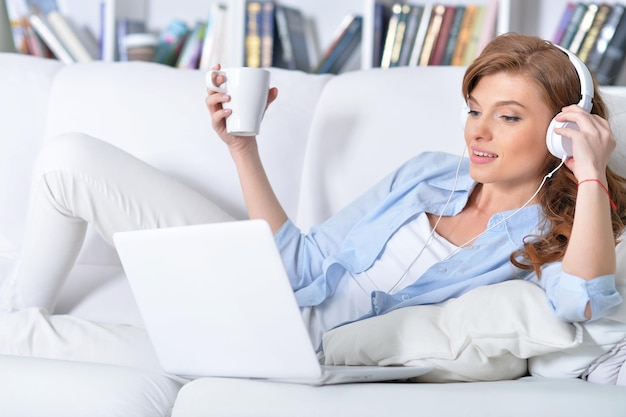 mujer joven, acostado, con, computador portatil