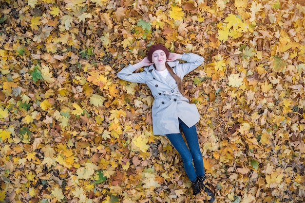 Mujer joven, acostado, en, hojas amarillas, en, bosque