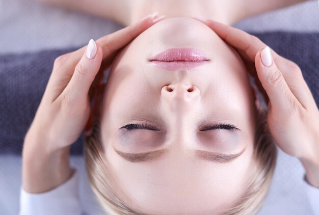 mujer joven, acostado, en, un, masaje, tablerelaxing, con, ojos cerrados, mujer, salón del balneario